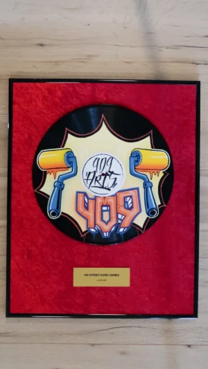 Eingerahmte Schallplatte auf rotem Samt mit Messingschild im Award-Stil, Layer One mit gelber Farbrolle im Graffiti-Design von 409 Arts