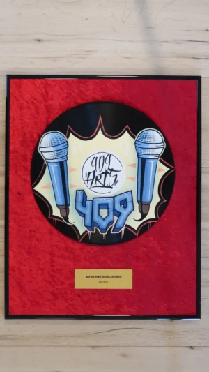 Eingerahmte Schallplatte auf rotem Samt mit Messingschild im Hip-Hop-Award-Stil, Mic Drop mit blauem Mikrofon im Graffiti-Design von 409 Arts