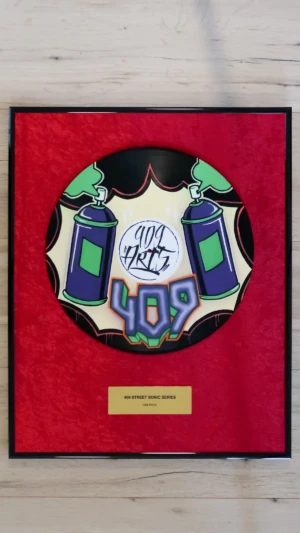 Eingerahmte Schallplatte auf rotem Samt mit Messingschild im Hip-Hop-Award-Stil, One Press mit lila Sprühdose im Graffiti-Design von 409 Arts