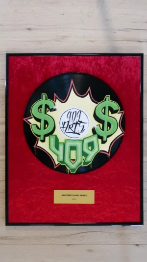 Eingerahmte Schallplatte auf rotem Samt mit Messingschild im Hip-Hop-Award-Stil, Side A mit grünem Dollarzeichen im Graffiti-Design von 409 Arts