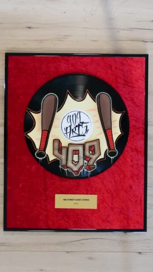 Eingerahmte Schallplatte auf rotem Samt mit Messingschild im Award-Stil, Side B mit braunem Baseballschläger im Graffiti-Design von 409 Arts