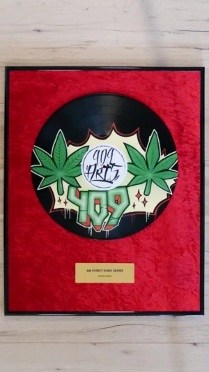 Eingerahmte Schallplatte auf rotem Samt mit Messingschild im Hip-Hop-Award-Stil, Smoke Signal mit grünem Cannabisblatt im Graffiti-Design von 409 Arts